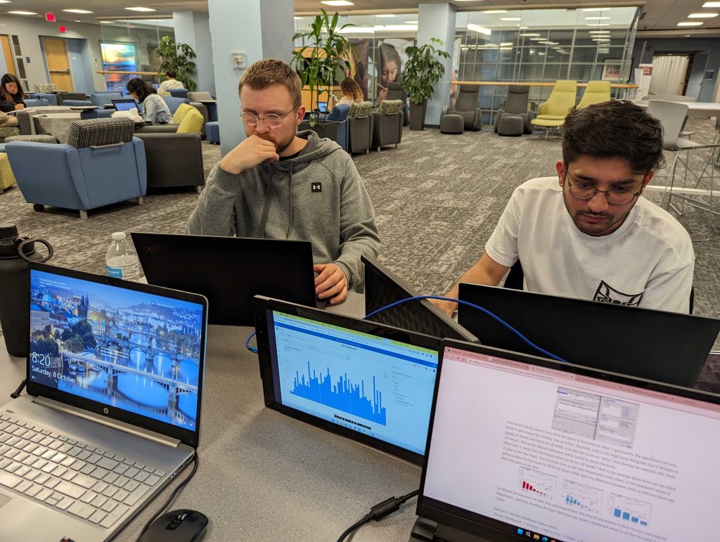 two male students working on laptops