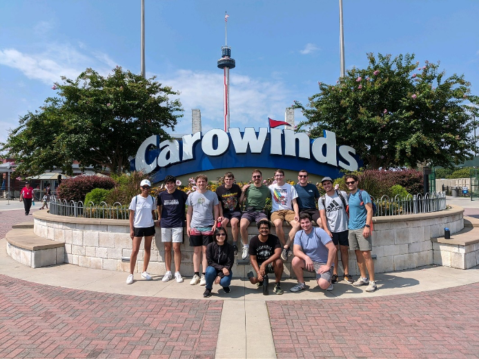 12 students in front of Carowinds sign