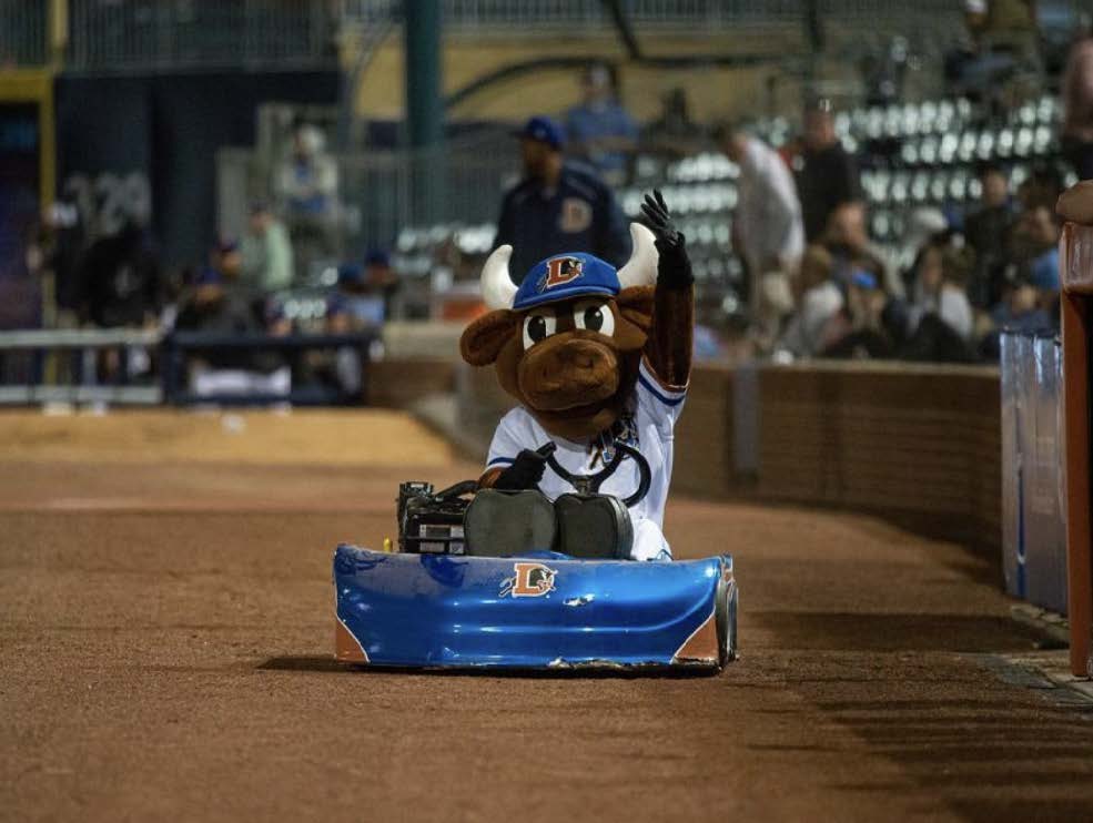 Sports mascot driving a go-Kart and waving to fans