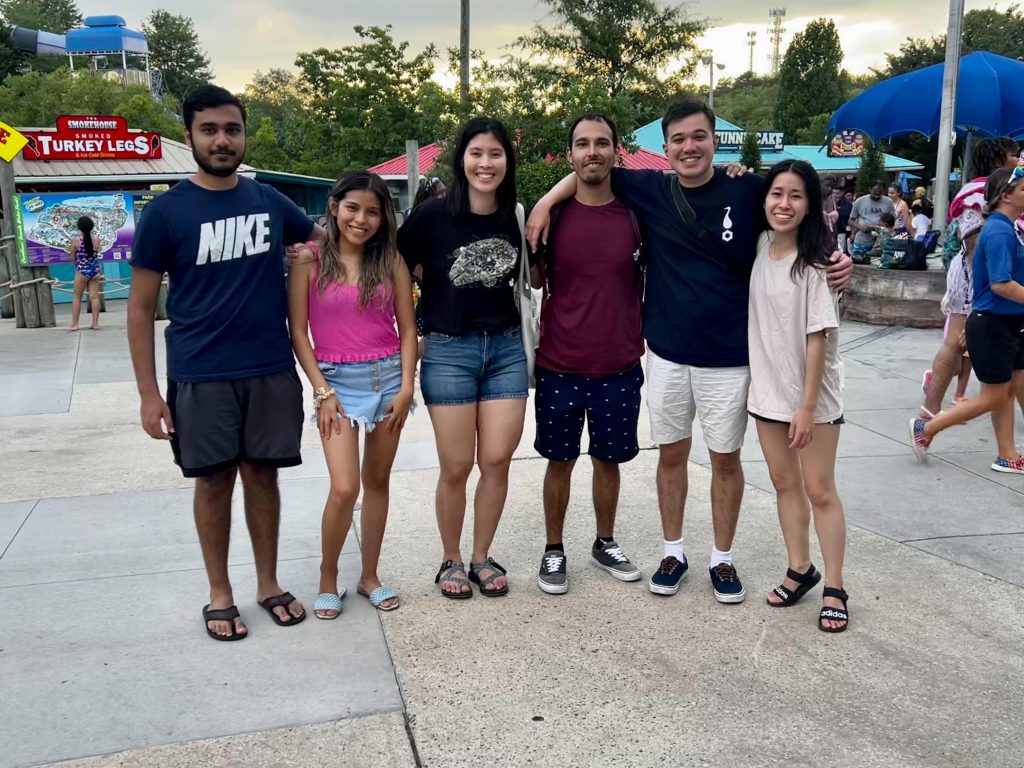 Group of 6 students posing together at a theme park