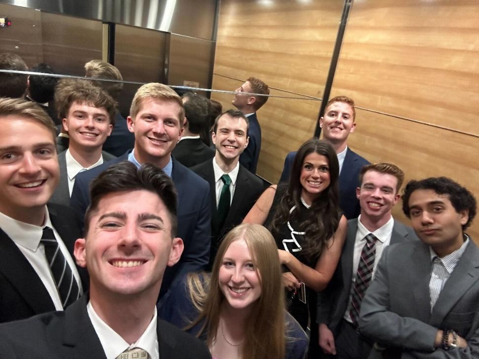 Group of students dressed in suits in elevator