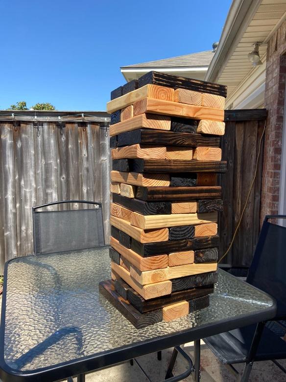 Outside table with large wooden blocks used for a game of Jenga.