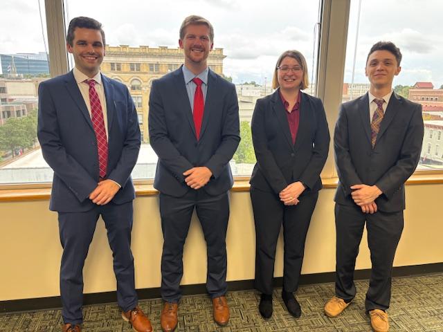 Four students dressed in professional suits